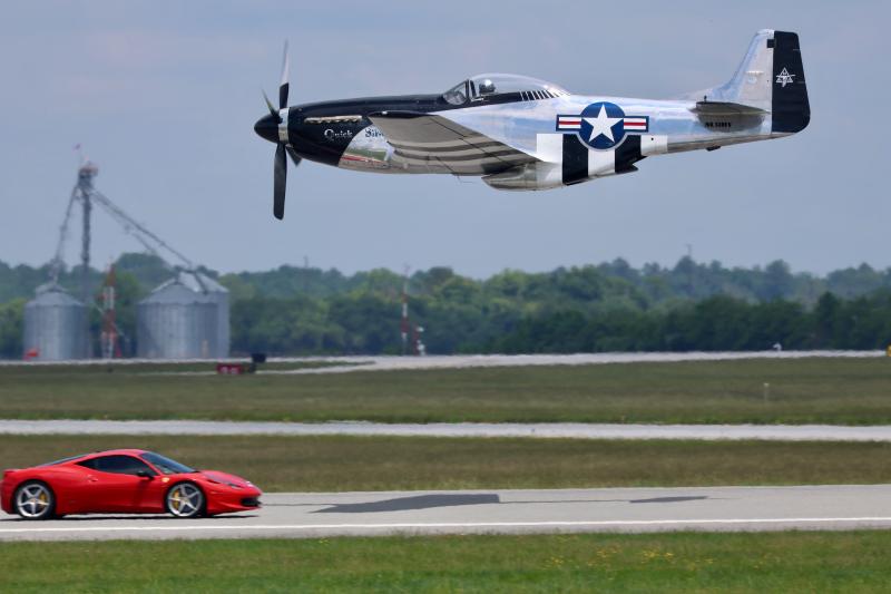 Ferrari vs. 51: A World War II-era P-51 Mustang flies past a car from Precision Exotic Cars. For $200, attendees could get a run down the runway in a Lamborghini, McClaren, Ferrari or Mustang Cobra at over 100 mph. A ride in the P-51 would have been priceless.